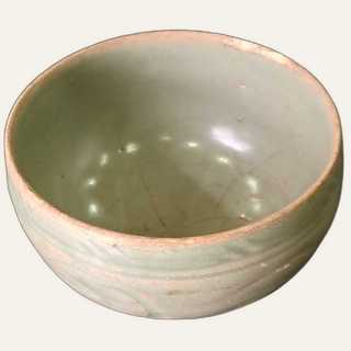 "Medium celadon-glazed ceramic bowl with incised swirling motif